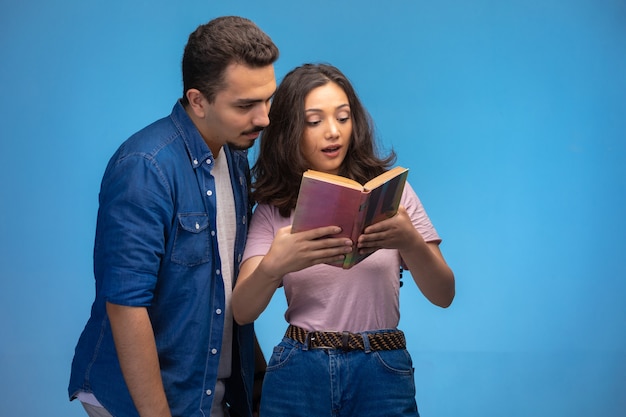 Young girl reading an old book with her partner.