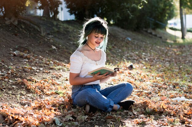 Young girl reading on sunny hill