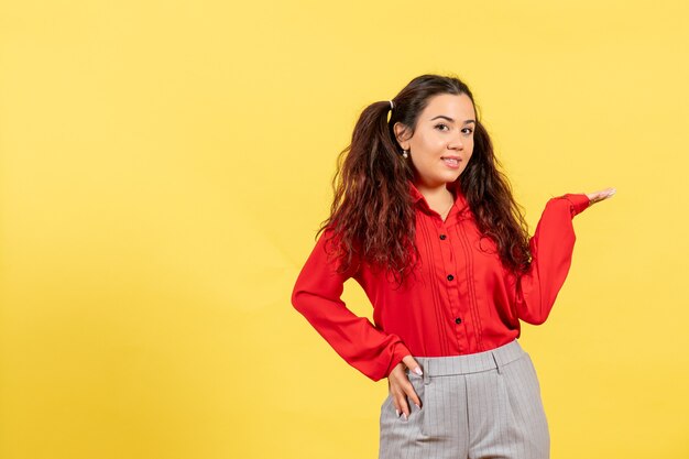 young girl in red blouse on yellow