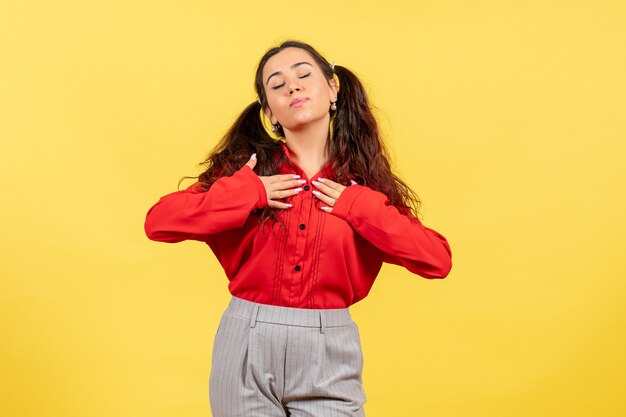 young girl in red blouse on yellow