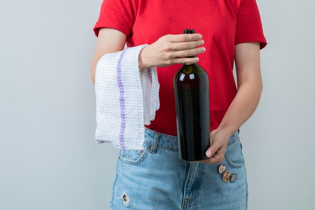 Young girl in red shirt holding a bottle of wine