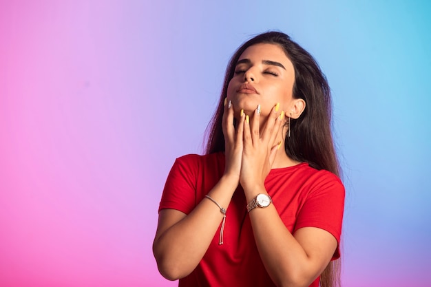 Giovane ragazza in camicia rossa, toccando il suo viso.