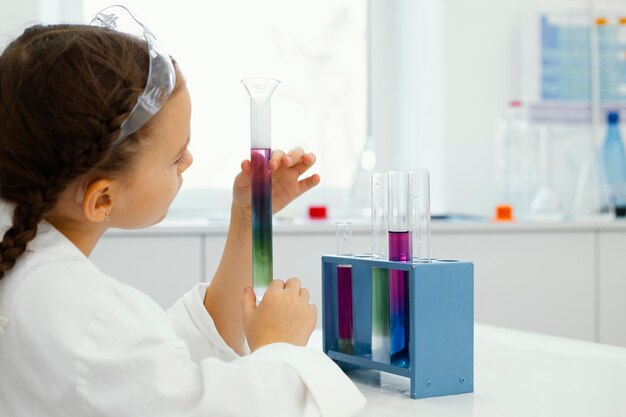 Young girl scientists with safety glasses doing experiments in the laboratory