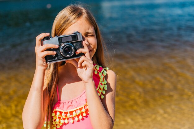 若い女の子が海を背景にカメラに撮影