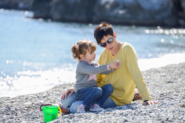 Young girl showing a seashell to her mother