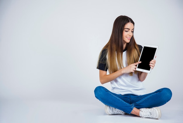 Young girl showing something from the tablet