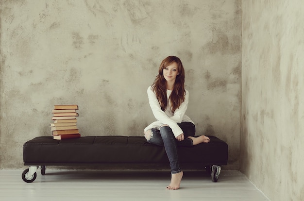 Free photo young girl sitting on the bench in the room