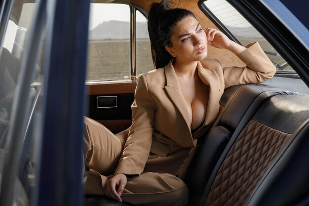 Young girl sitting on a car on back seat and looking away High quality photo