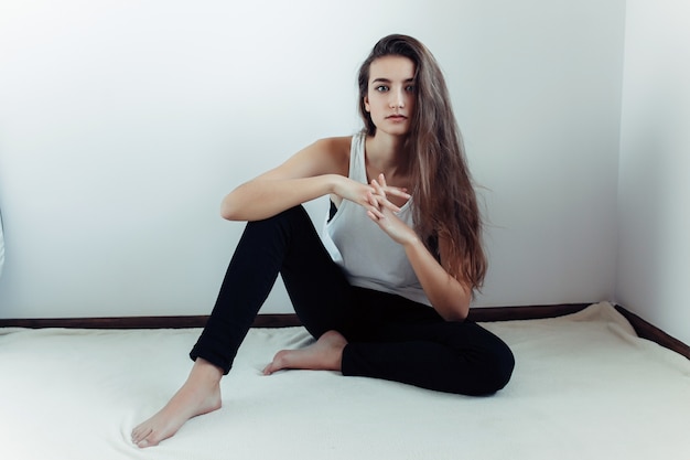 Young girl sitting on the floor with fingers crisscrossed