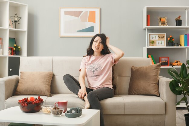 Young girl sitting on sofa behind coffee table in living room