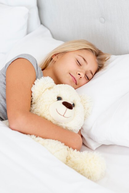 Young girl slipping with her toy bear