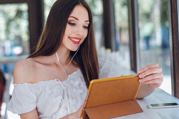 Young girl smiling while looking at a tablet