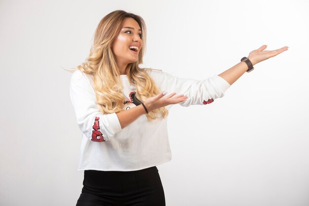 Young girl in sport outfits pointing something on the right