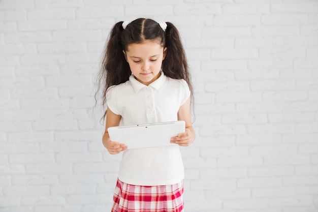 Free photo young girl standing holding tablet