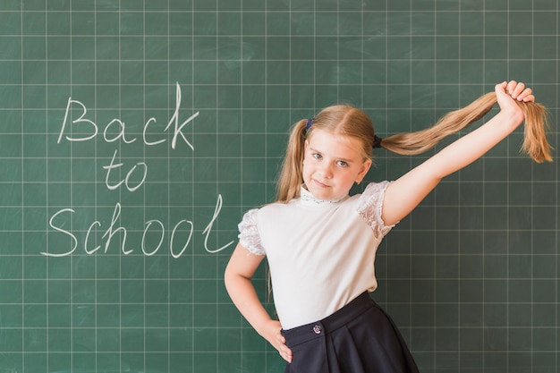 Free photo young girl standing near blackboard