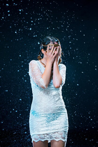 The young girl standing under running water