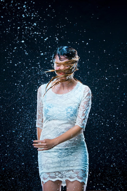 Free photo the young girl standing under running water