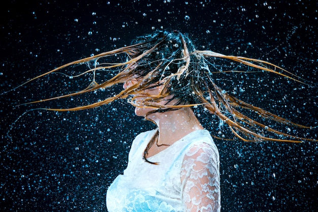 Free photo young girl standing under running water