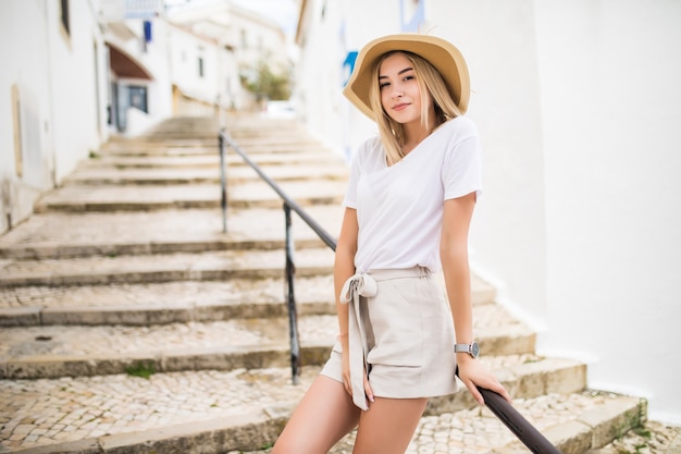 Free photo young girl standing on the stone stairs and handrail at the street in summer