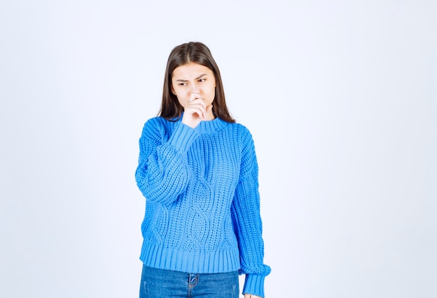 young girl in sweater feeling awful on white.