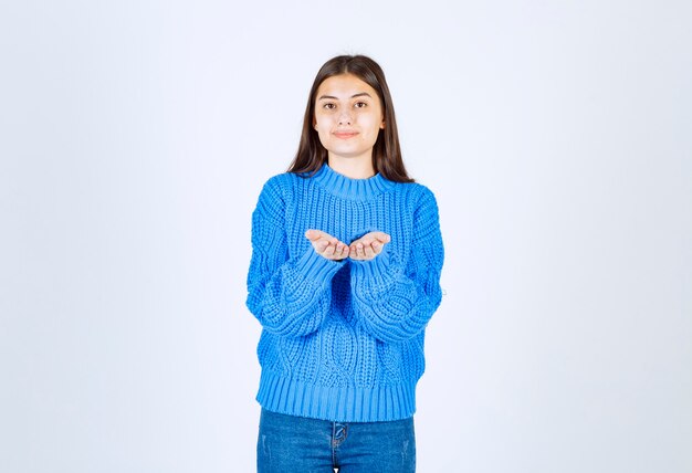 young girl in sweater showing her hands on white.