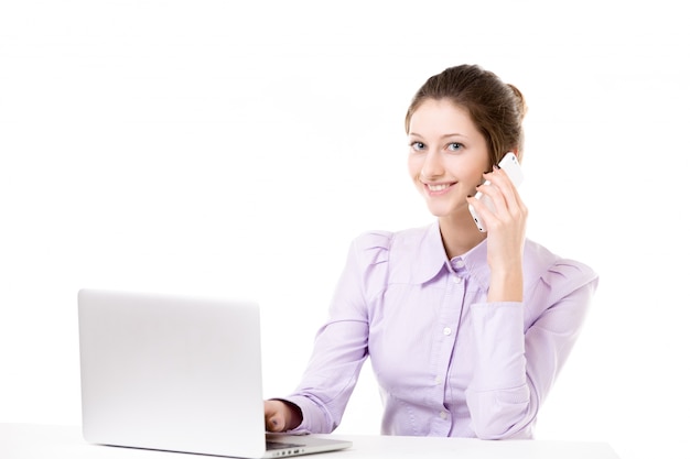 Young girl taking business call in front of laptop