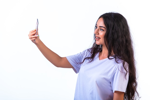 Free photo young girl taking her selfie on the mobile phone