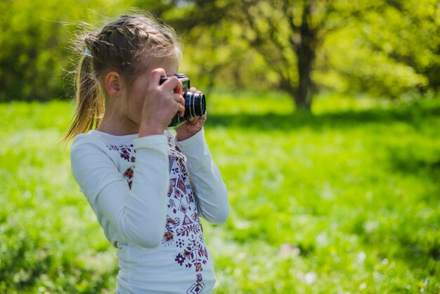 Young girl taking a photo in the park