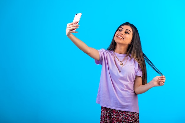 그녀의 전화에서 selfie를 복용하는 어린 소녀.