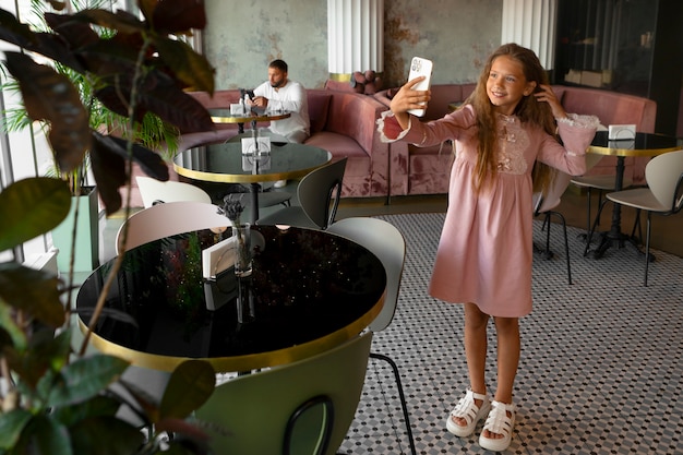Молодая девушка делает селфи в ресторане
