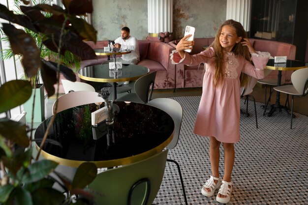 Young girl taking a selfie at restaurant