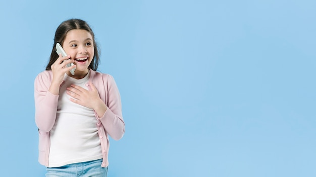 Free photo young girl talking on mobile in studio