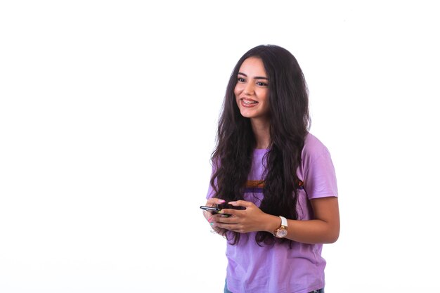 Young girl talking online with friends and smiling.