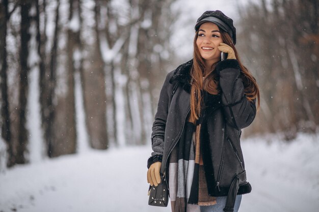 Young girl talking on the phone in a winter park