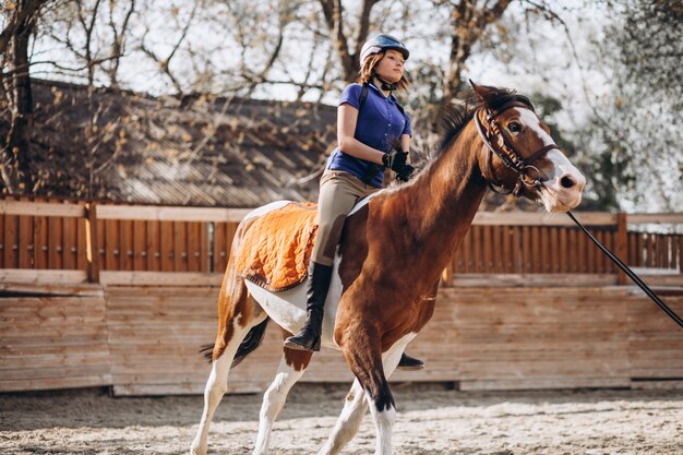 Young girl teaching horse riding