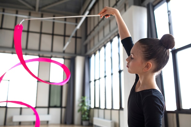 Foto gratuita giovane ragazza che si allena in ginnastica