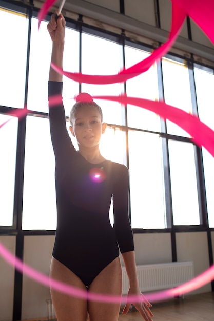 Foto gratuita giovane ragazza che si allena in ginnastica