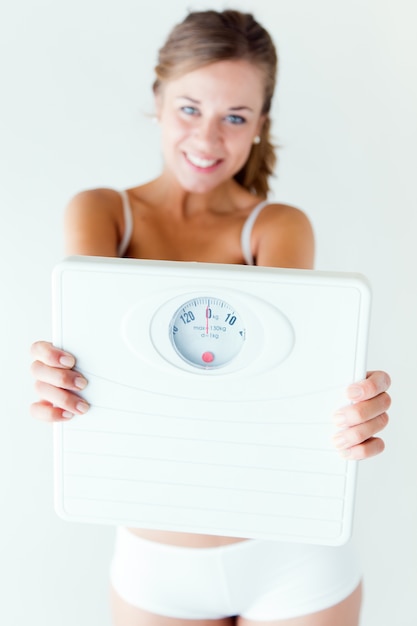 Free photo young girl in underwear holding scales.