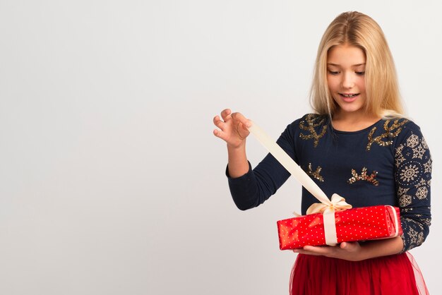 若い女の子のクリスマスプレゼントを開ける