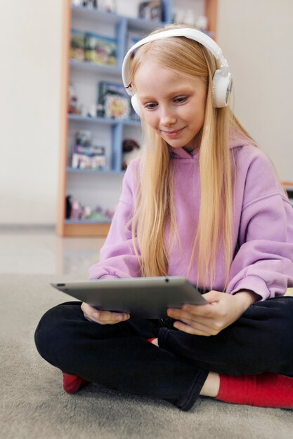 Young girl using a tablet to work and listening to music