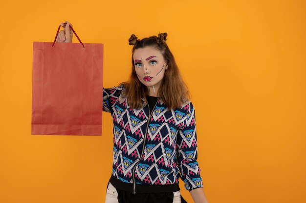 Young girl wearing fantasy makeup and holding bag. High quality photo