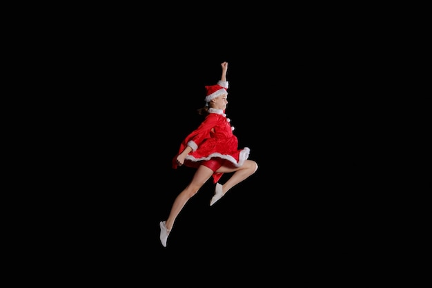 산타 복장을 한 어린 소녀가 날고 있습니다. 크리스마스 시간, 어린 시절, 동화.