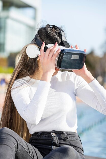 어린 소녀는 공원에서 VR 세트를 착용