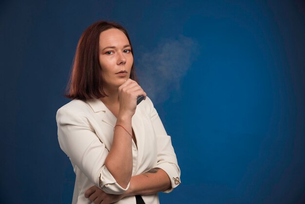 Young girl in white blazer posing as a professional. 