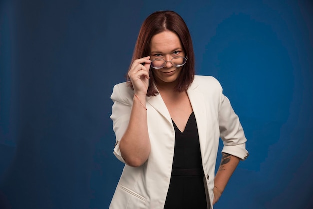 Free photo young girl in white blazer wearing optique eyeglasses.