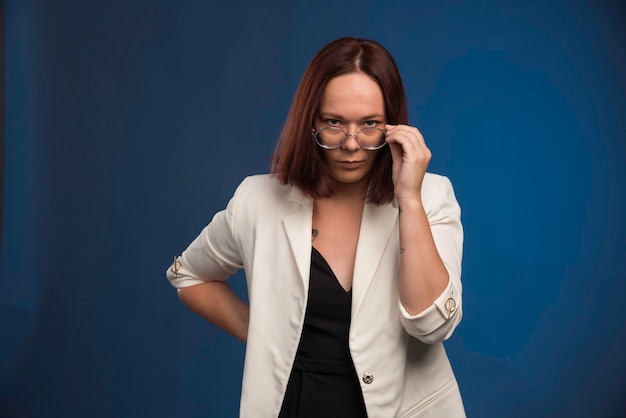 Free photo young girl in white blazer wearing optique eyeglasses.