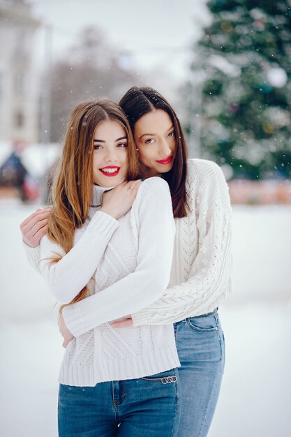 Young girl in a white sweater standing in a winter park