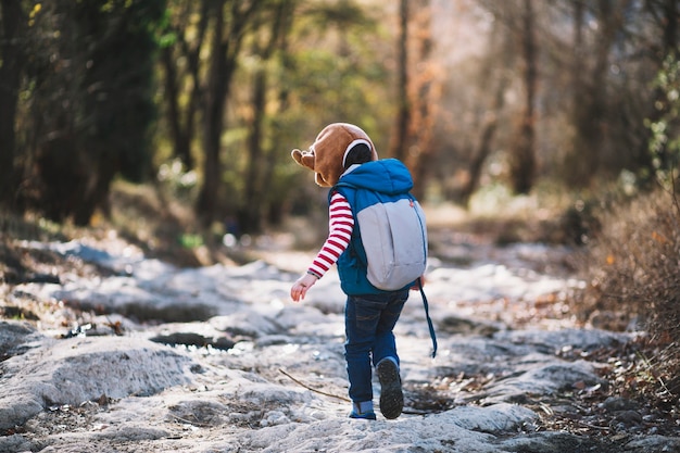 Young girl with backpack in woods