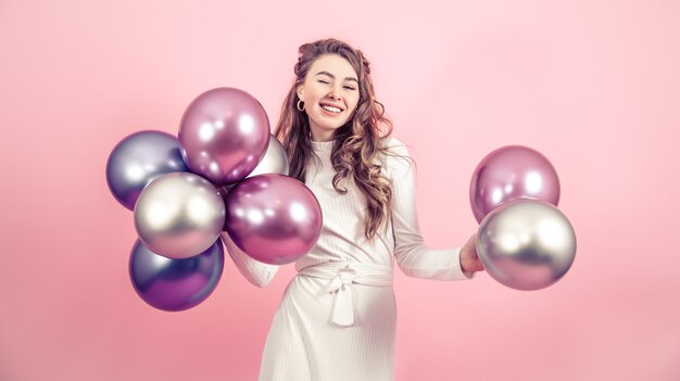 Young girl with balls on a colored background