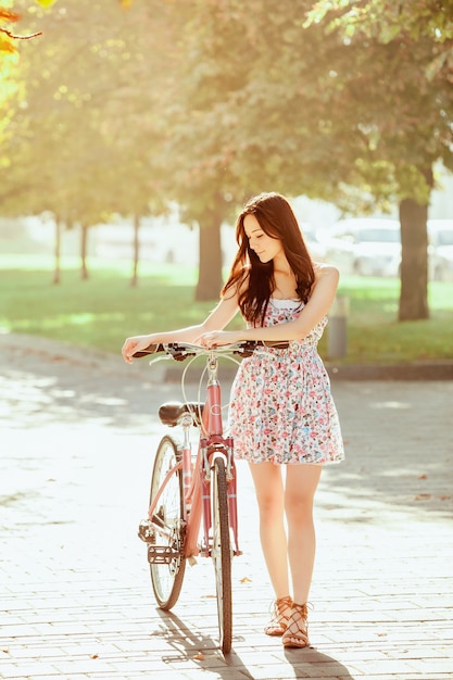 The young girl with bicycle in park